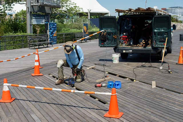A man making repairs to Coney Island's boardwalk in 2018